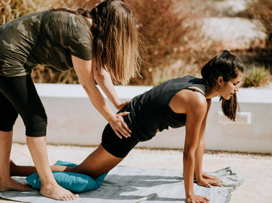 instructor assisting in yoga posture